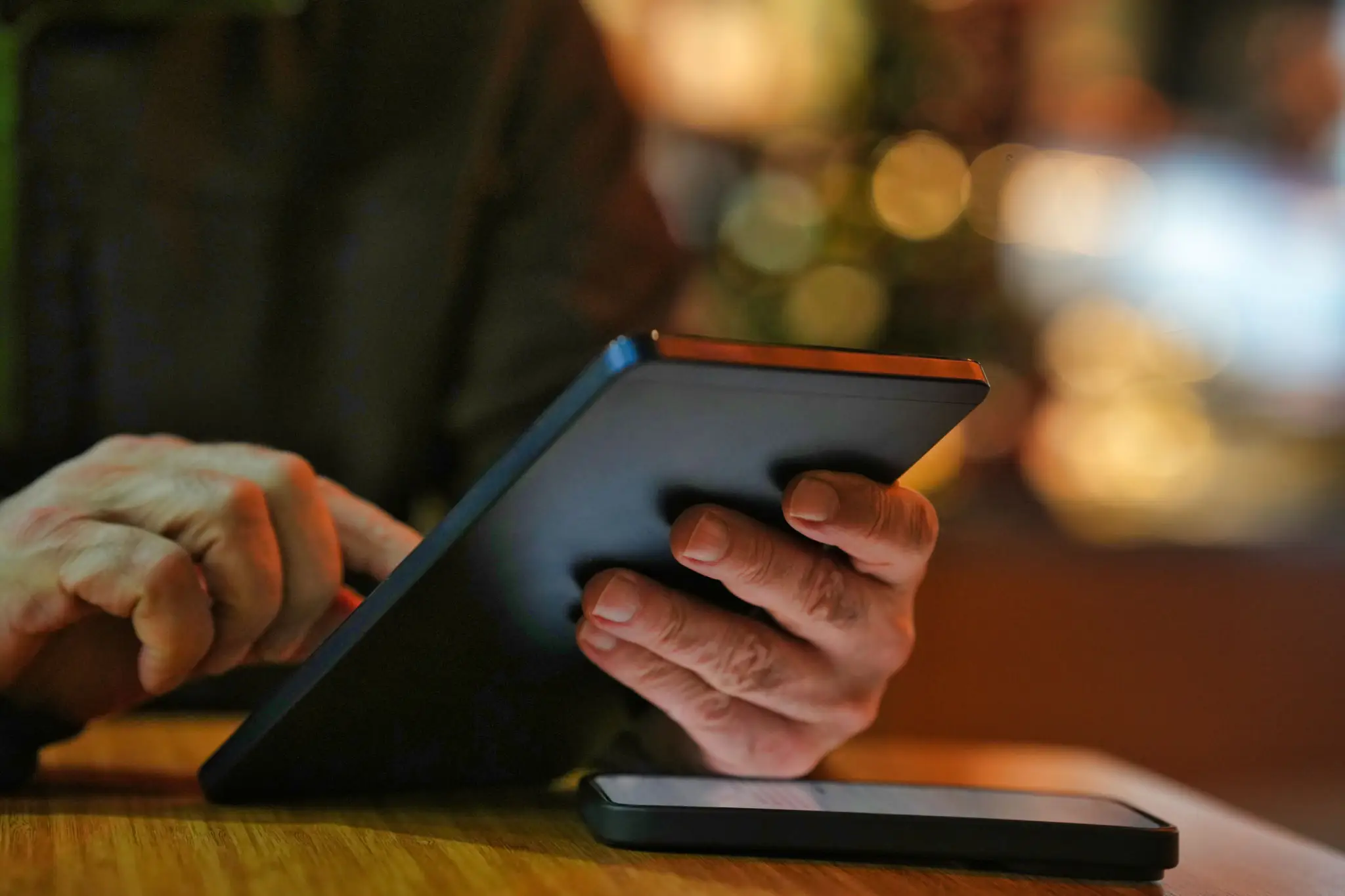 03f87e84-090c-45ad-955e-8a03c8abe2fe A person is using an ipad on the table